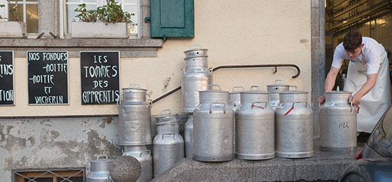 Milk churns outside the village dairy in Marsens, district of Gruyère
