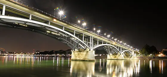 Das Bild zeigt eine hell erleuchtete Brücke.