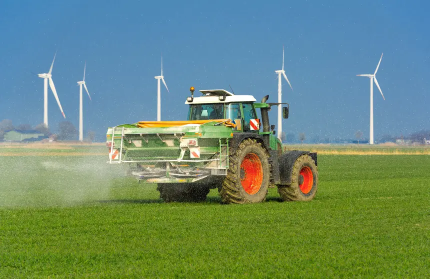 Tracteur avec épandeur d’engrais dans un champ de maïs