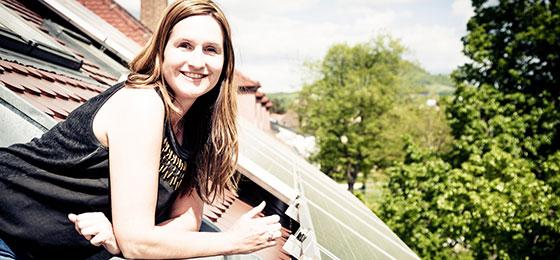 Das Bild zeigt eine Frau auf einem Balkon.