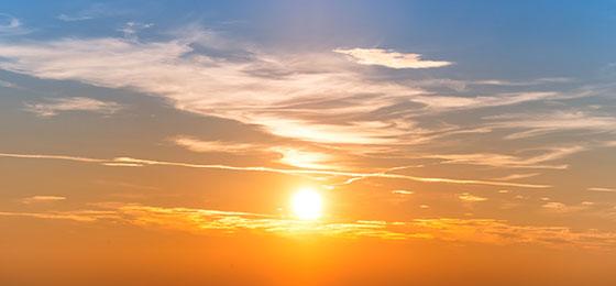 Das Bild zeigt die Sonne am Himmel mit Wolken. 